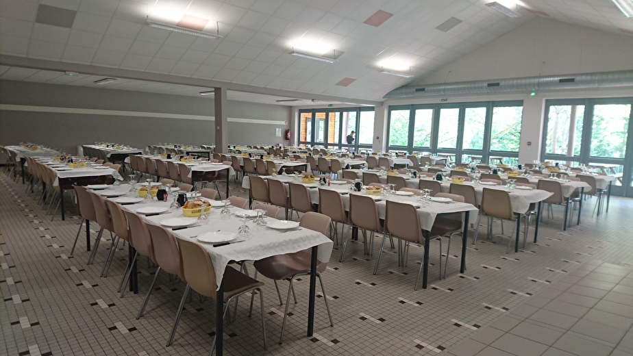 Réfectoire avec tables dressées pour évènement